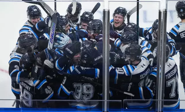 Chicoutimi Sagueneens' Liam Lefebvre (39) is mobbed by his teammates after scoring the winning goal during the first overtime period of a Memorial Cup hockey game against the Kelowna Rockets in Kelowna, British Columbia, Sunday, May 24, 2026. (Darryl Dyck/The Canadian Press via AP)