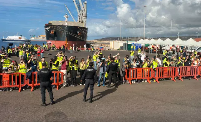 Media members work next the hantavirus-stricken cruise ship MV Hondius at the port of Granadilla in Tenerife, Canary Islands, Spain, Sunday, May 10, 2026. (AP Photo)