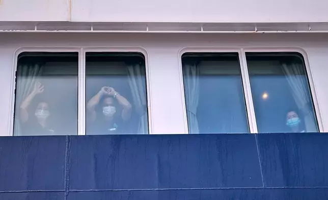 Passengers watch as others are disembarked from the hantavirus-stricken cruise ship MV Hondius at the port of Granadilla in Tenerife, Canary Islands, Spain, Sunday, May 10, 2026. (AP Photo)