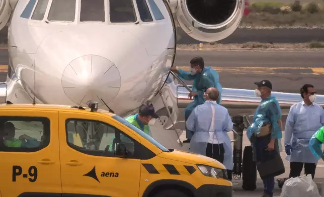A passenger boards a French government plane after disembarking from the hantavirus-stricken cruise ship MV Hondius at the airport in Tenerife, Canary Islands, Spain, Sunday, May 10, 2026. (AP Photo/Arturo Rodriguez)