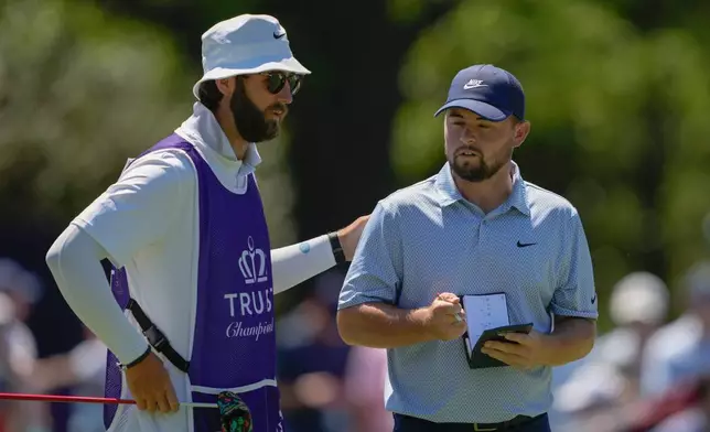 Alex Fitzpatrick, of England, reacts with his caddie after a birdie on the fifth hole during the final round of the Truist Championship golf tournament at the Quail Hollow Club, Sunday, May 10, 2026, in Charlotte, N.C. (AP Photo/Chris Carlson)