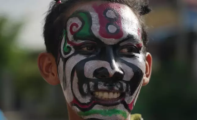 A man with a ghost painting takes part in a ceremony to invoke rain amid the rice planting season in Pring Ka-ek village, northwest of Phnom Penh, Cambodia, Thursday, May 21, 2026. (AP Photo/Heng Sinith)