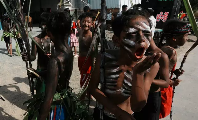 Boys representing ghosts participate during a ceremony to invoke rain amid the rice planting season in Pring Ka-ek village, northwest of Phnom Penh, Cambodia, Thursday, May 21, 2026. (AP Photo/Heng Sinith)