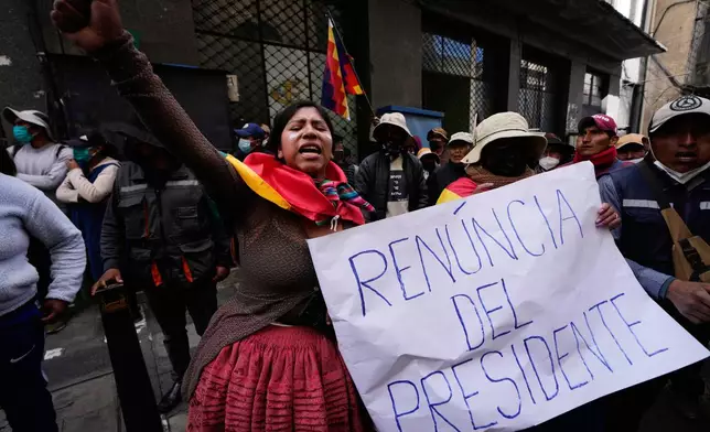 An anti-government protester holds a sign that reads in Spanish "Resignation of the president" in La Paz, Bolivia, Monday, May 18, 2026. (AP Photo/Juan Karita)