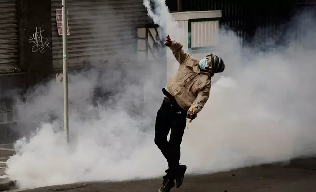 A protester returns a tear gas canister to police during an anti-government protest in La Paz, Bolivia, Monday, May 18, 2026. (AP Photo/Freddy Barragan)