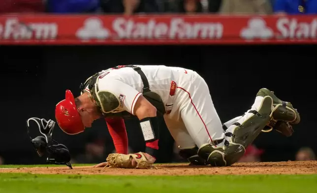 Los Angeles Angels catcher Logan O'Hoppe crawls around home plate after being injured on a pitch to Los Angeles Dodgers' Will Smith during the sixth inning of a baseball game Saturday, May 16, 2026, in Anaheim, Calif. (AP Photo/Mark J. Terrill)