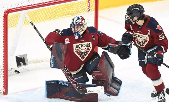 Montreal Victoire goaltender Ann-Renee Desbiens (35) looks back on her net after being scored on by Minnesota Frost's Jincy Roese, not shown, as Victoire's Maggie Flaherty (91) looks on during the overtime period of a PWHL playoff hockey game in Laval, Quebec, Saturday, May 2, 2026. (Graham Hughes/The Canadian Press via AP)