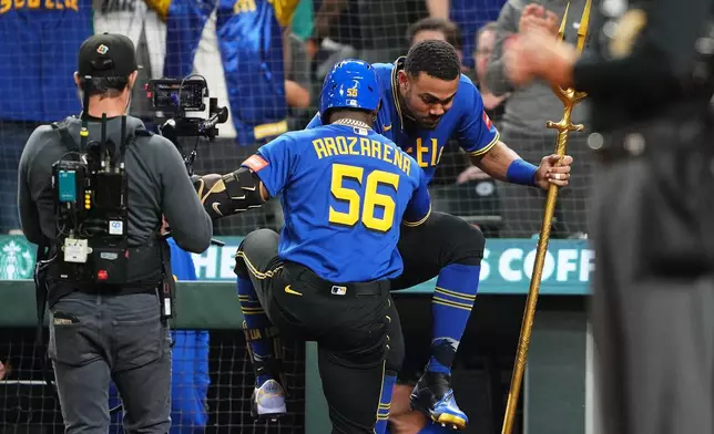 Seattle Mariners' Randy Arozarena (56) celebrates his solo home run with Julio Rodríguez, facing, against the Kansas City Royals during the sixth inning of a baseball game, Friday, May 1, 2026, in Seattle. (AP Photo/Lindsey Wasson)