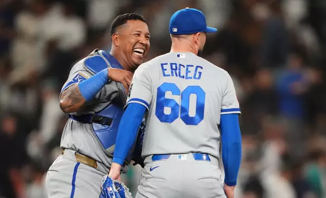 Kansas City Royals catcher Salvador Perez celebrates with relief pitcher Lucas Erceg (60) after a win over the Seattle Mariners in a baseball game, Friday, May 1, 2026, in Seattle. (AP Photo/Lindsey Wasson)