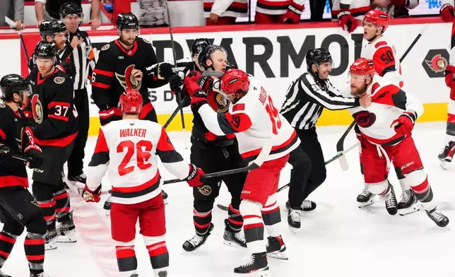 Ottawa Senators left wing Brady Tkachuk, center left, and Carolina Hurricanes defenseman K'andre Miller (19) fight during the second period of Game 4 in a first-round NHL hockey Stanley Cup playoff series in Ottawa, Ontario, Saturday, April 25, 2026. (Sean Kilpatrick/The Canadian Press via AP)