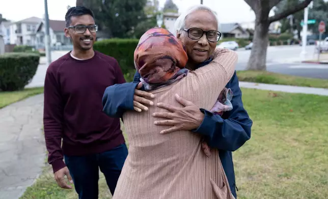 Mohammed Rashid, right, hugs his daughter in law Samiha Matin goodbye as his son, Faisal Rashid watches outside of their home in Pasadena Calif, Sunday, May 17, 2026, in Pasadena, Calif. (AP Photo/Ryan Sun)