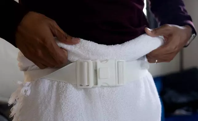 Faisal Rashid practices wearing his ihram robe as he packsfor the annual Hajj pilgrimage in Mecca, Saudi Arabia, at his home in Pasadena, Calif, Sunday, May 17, 2026. (AP Photo/Ryan Sun)