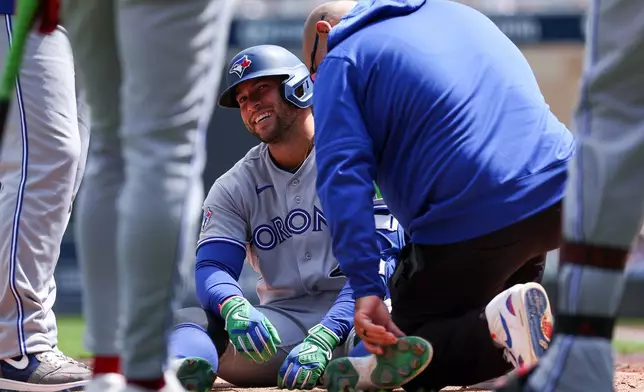 Toronto Blue Jays designated hitter George Springer is tended to after getting hit by a pitch during the third inning of a baseball game against the Minnesota Twins, Saturday, May 2, 2026, in Minneapolis. (AP Photo/Matt Krohn)