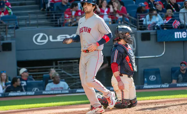 Boston Red Sox' Marcelo Mayer, left, scores on a double by Connor Wong as Cleveland Guardians' Austin Hedges looks away during the sixth inning of a baseball game, Saturday, May 30, 2026, in Cleveland. (AP Photo/Phil Long)
