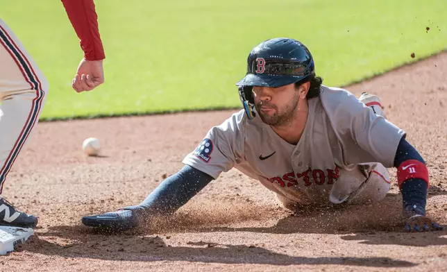 Boston Red Sox' Marcelo Mayer dives safely back to first base then takes second on a bad throw by Cleveland Guardians relief pitcher Matt Festa during the sixth inning of a baseball game, Saturday, May 30, 2026, in Cleveland. (AP Photo/Phil Long)