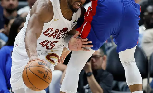 Cleveland Cavaliers guard Donovan Mitchell (45) collides with Detroit Pistons forward Tobias Harris (12) while trying to move the ball during the first half in Game 7 of a second-round NBA playoffs basketball series Sunday, May 17, 2026, in Detroit. (AP Photo/Duane Burleson)