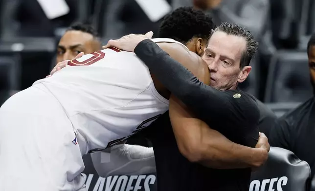 Cleveland Cavaliers guard Donovan Mitchell hugs head coach Kenny Atkinson as he leaves the game against the Detroit Pistons during the fourth quarter of Game 7 in a second-round NBA basketball playoffs series, Sunday, May 17, 2026, in Detroit. (AP Photo/Duane Burleson)
