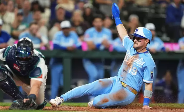 Kansas City Royals' Michael Massey scores on an RBI sacrifice fly from Isaac Collins ahead of the throw to Seattle Mariners catcher Mitch Garver during the 10th inning of a baseball game, Saturday, May 2, 2026, in Seattle. (AP Photo/Lindsey Wasson)