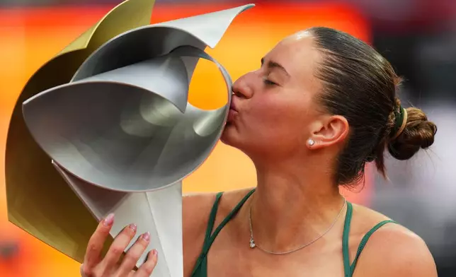 Marta Kostyuk of Ukraine kisses the trophy after winning the final match at the Madrid Open tennis tournament in Madrid, Spain, Saturday, May 2, 2026. (AP Photo/Manu Fernandez)