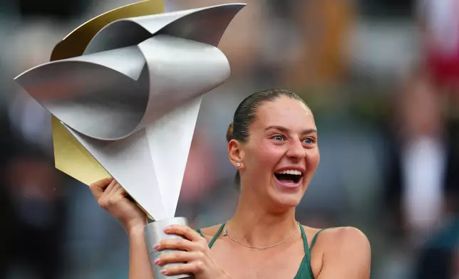 Marta Kostyuk of Ukraine celebrates with the trophy after winning the final match at the Madrid Open tennis tournament in Madrid, Spain, Saturday, May 2, 2026. (AP Photo/Manu Fernandez)