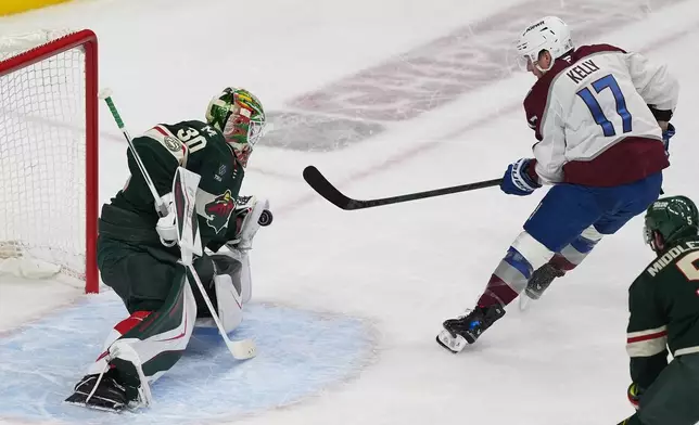 Minnesota Wild goaltender Jesper Wallstedt (30) blocks a shot by Colorado Avalanche center Parker Kelly (17) during the first period of Game 3 of an NHL Stanley Cup hockey second-round playoff series Saturday, May 9, 2026, in St. Paul, Minn. (AP Photo/Abbie Parr)