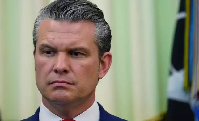 Defense Secretary Pete Hegseth listens as President Donald Trump speaks before signing a proclamation in the Oval Office at the White House, Tuesday, May 5, 2026, in Washington. (AP Photo/Jacquelyn Martin)