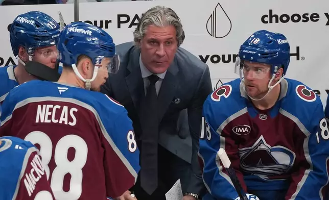 Colorado Avalanche head coach Jared Bednar, center, confers with players during a timeout in the third period of Game 1 of an NHL hockey Stanley Cup second-round playoff series against the Minnesota Wild Sunday, May 3, 2026, in Denver. (AP Photo/David Zalubowski)