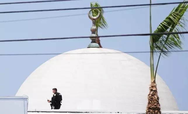 Police stage on a roof at the scene of a shooting outside the Islamic Center of San Diego Monday, May 18, 2026, in San Diego. (AP Photo/Gregory Bull)