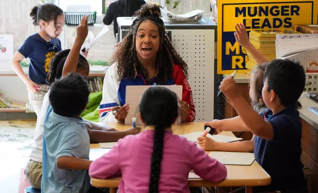 Teacher, Aja Penick, works with first graders at Munger Elementary-Middle School Thursday, May 7, 2026, in Detroit. (AP Photo/Paul Sancya)
