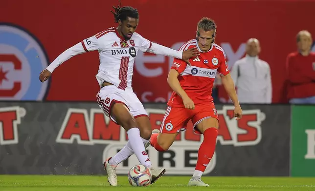 Toronto FC defender Zane Monlouis, left, controls the ball against Chicago Fire midfielder Robin Lod, right, during the second half of an MLS soccer match Saturday, May 23, 2026, in Chicago. (AP Photo/Melissa Tamez)