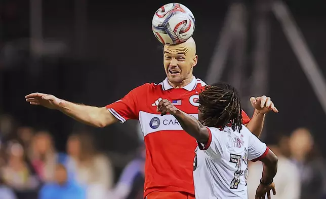 Chicago Fire defender Andrew Gutman, middle, heads the ball over Toronto FC midfielder Malik Henry during the second half of an MLS soccer match Saturday, May 23, 2026, in Chicago. (AP Photo/Melissa Tamez)