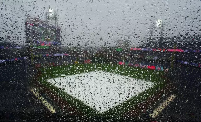 Rain water collects on glass prior to the start of a baseball game between the Philadelphia Phillies and the Cleveland Guardians, Saturday, May 23, 2026, in Philadelphia. (AP Photo/Derik Hamilton)