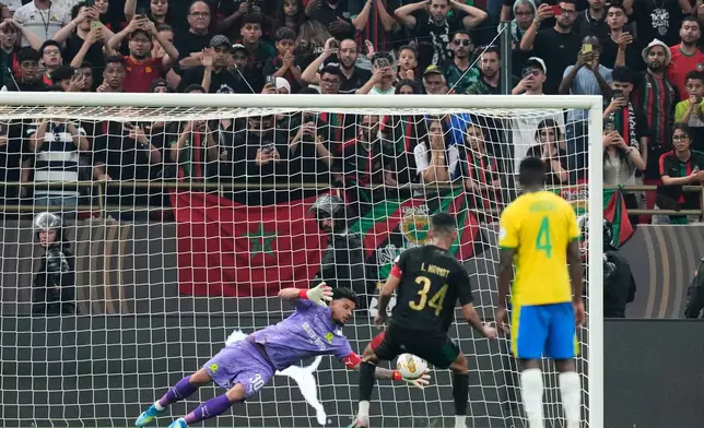Mamelodi Sundowns' goalkeeper Ronwen Williams, left, dives to safe a penalty kick by AS FAR Rabat's captain Mohamed Rabie Hrimat, center, during the CAF Champions League final soccer match between AS FAR Rabat and Mamelodi Sundowns, in Rabat, Morocco, Sunday, May 24, 2026. (AP Photo/Mosa'ab Elshamy)