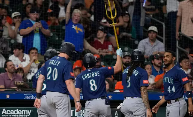 Seattle Mariners' Dominic Canzone (8) celebrates after hitting a grand slam against the Houston Astros during the fourth inning of a baseball game Tuesday, May 12, 2026, in Houston. (AP Photo/David J. Phillip)