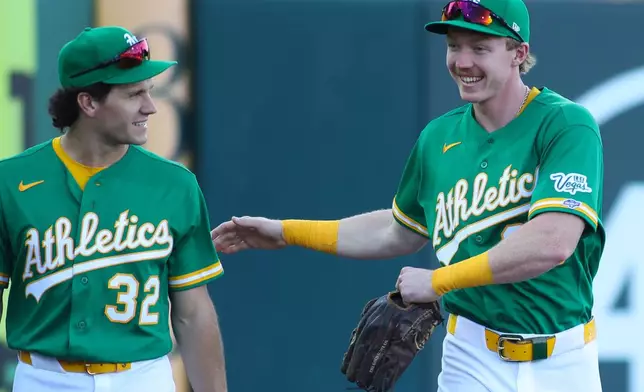 Athletics' Henry Bolte, right, talks with Colby Thomas before making his MLB debut before a baseball game against the St. Louis Cardinals, Wednesday, May 13, 2026, in West Sacramento, Calif. (AP Photo/Scott Marshall)