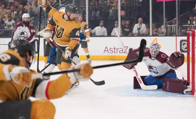 Colorado Avalanche goaltender Scott Wedgewood, right, deflects a shot by Vegas Golden Knights defenseman Kaedan Korczak, left, during the second period in Game 3 of the Western Conference finals NHL hockey Stanley Cup playoff series Sunday, May 24, 2026, in Las Vegas. (AP Photo/Mark J. Terrill)