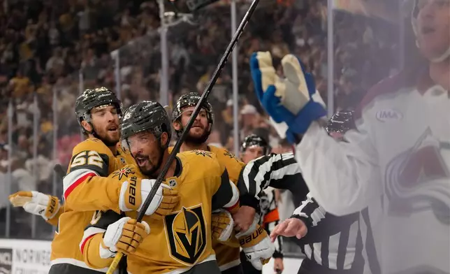 Vegas Golden Knights right wing Keegan Kolesar, second from left, is held back after Colorado Avalanche defenseman Josh Manson, right, shoved him into the boards after Kolesar scored during the second period in Game 3 of the Western Conference finals NHL hockey Stanley Cup playoff series Sunday, May 24, 2026, in Las Vegas. (AP Photo/Mark J. Terrill)