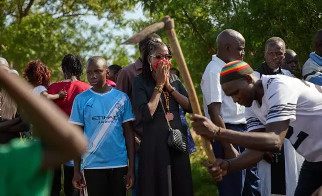 A family member grieves at the burial of a relative on the outskirts of Kisumu, Kenya, Friday, March 13, 2026. (AP Photo/Asa Wallin)