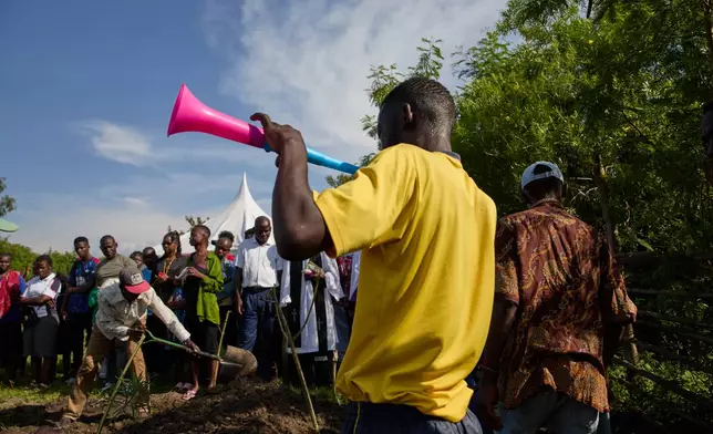 Family and friends shovel dirt onto the coffin of Tom Ochieng Mima on the outskirts of Kisumu, Kenya, Friday, March 13, 2026. (AP Photo/Asa Wallin)