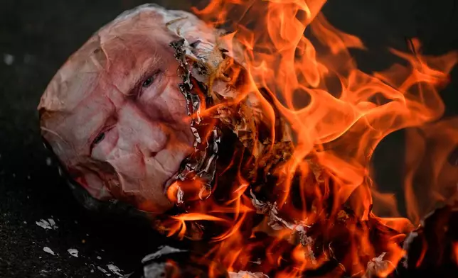 FILE - An effigy of President Donald Trump goes up in flames during an International Workers' Day march marking May Day in Panama City, May 1, 2026. (AP Photo/Matias Delacroix, File)