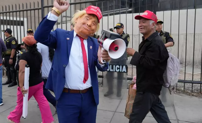 FILE - A man wearing a Donald Trump mask takes part in a rally of supporters for presidential candidate Rafael Lopez Aliaga in Lima, Peru, May 6, 2026. (AP Photo/Martin Mejia, File)