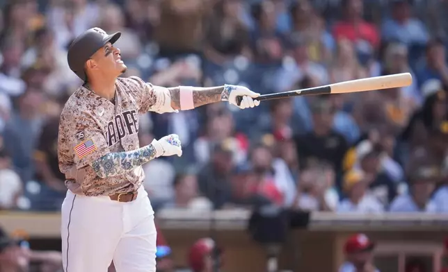 San Diego Padres' Manny Machado watches his walk off sacrifice fly during the tenth inning of a baseball game against the St. Louis Cardinals Sunday, May 10, 2026, in San Diego. San Diego Padres' Nick Castellanos scored from third base on the play. (AP Photo/Gregory Bull)