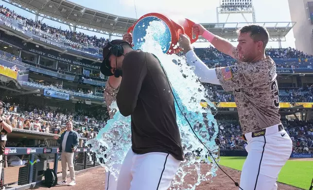 San Diego Padres' Nick Castellanos, center, is doused by teammate Gavin Sheets after the Padres defeated the St. Louis Cardinals 3-2 in a baseball game Sunday, May 10, 2026, in San Diego. (AP Photo/Gregory Bull)