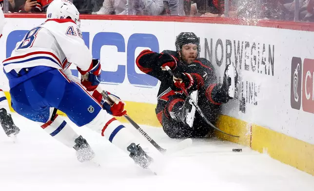 Carolina Hurricanes' Taylor Hall (71) crashes into the boards with Montréal Canadiens' Lane Hutson (48) nearby during the second period in Game 1 of the Eastern Conference finals NHL hockey Stanley Cup playoffs series in Raleigh, N.C., Thursday, May 21, 2026. (AP Photo/Karl DeBlaker)