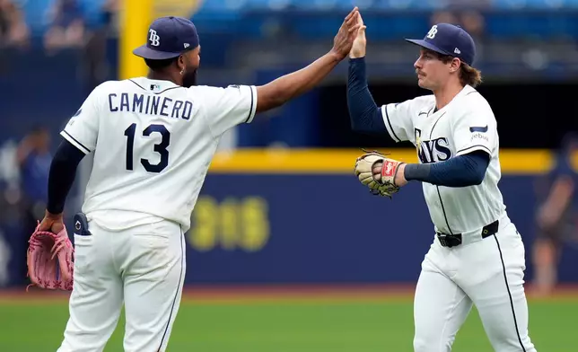 Tampa Bay Rays third baseman Junior Caminero (13) and right fielder Jonny DeLuca celebrate after the team defeated the Toronto Blue Jays during a baseball game Wednesday, May 6, 2026, in St. Petersburg, Fla. (AP Photo/Chris O'Meara)