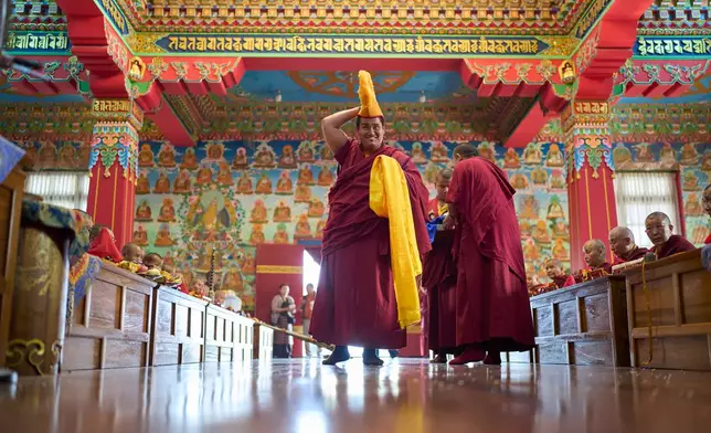 Jalue Dorje adjusts his ceremonial hat before starting a ritual at Dzarong Thubten Mindrol Dongä Monastery in Kathmandu, Nepal, Tuesday, April 14, 2026. (AP Photo/Niranjan Shrestha)