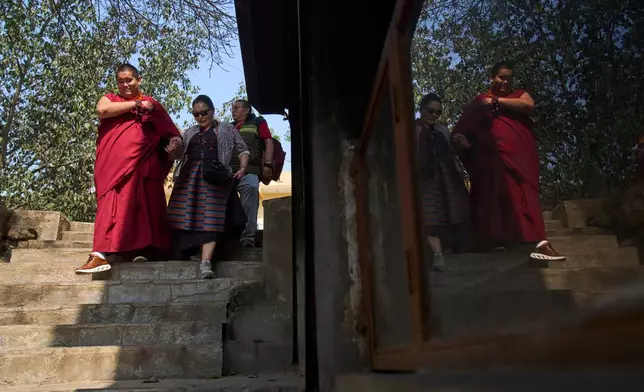 Jalue Dorje, left; his mother, Dechen Wangmo, center, and his father, Dorje Tsegyal walk towards the Halesi-Maratika Caves, 135 miles east of Kathmandu, Nepal, Monday, April 13, 2026. (AP Photo/Niranjan Shrestha)