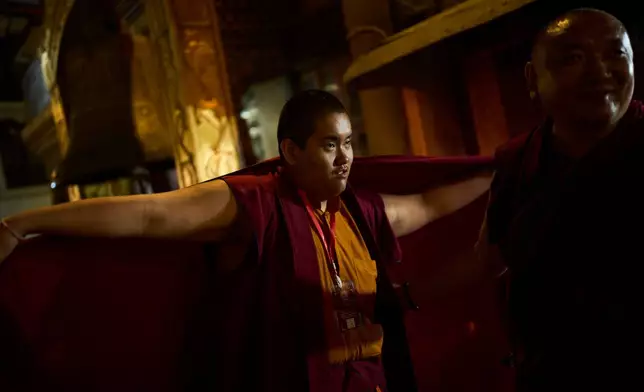 Jalue Dorje fixes his monastic robes while he circumambulates the World Heritage site Boudhanath Stupa in Kathmandu, Nepal, Monday, April 6, 2026. (AP Photo/Niranjan Shrestha)