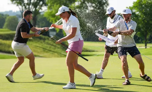 Lottie Woad, center, celebrates with teammates after winning the Queen City Championship LPGA golf tournament at Maketewah Country Club, Sunday, May 17, 2026, in Cincinnati. (AP Photo/Jeff Dean)