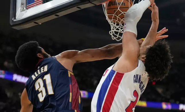 Detroit Pistons guard Cade Cunningham (2) dunks as Cleveland Cavaliers center Jarrett Allen (31) defends in the second half of Game 3 of a second-round NBA playoffs basketball series Saturday, May 9, 2026 in Cleveland. (AP Photo/Sue Ogrocki)